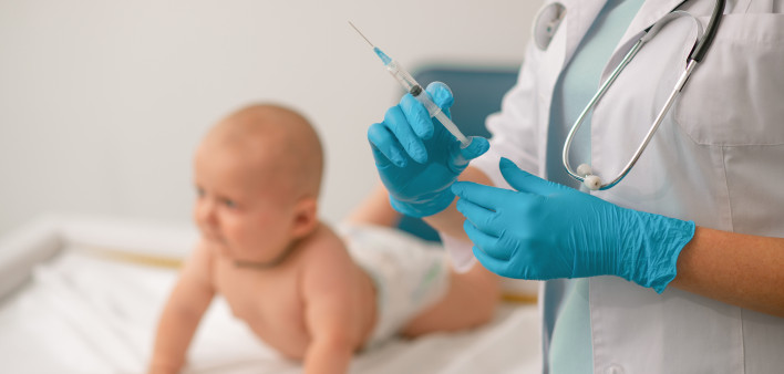 Doctor in nitrile gloves preparing to administer an injection