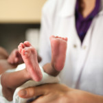 nurse holding baby showing feet