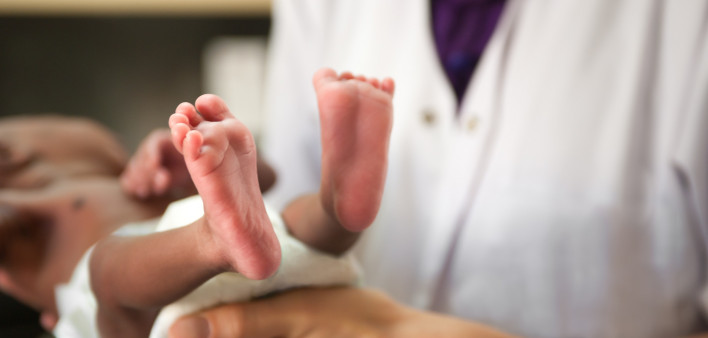 nurse holding baby showing feet