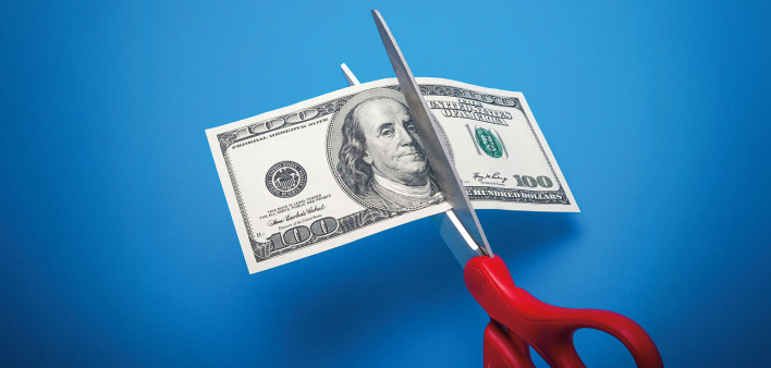 scissors cutting 100 dollar bill