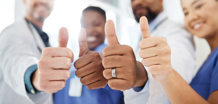 doctors, nurses and patient giving thumbs up