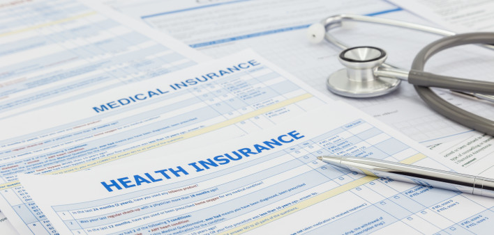 Medical insurance application, silver pen and stethoscope. Legal law contract and health insurance concepts.