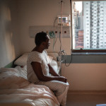 black patient in the hospital sitting in bed