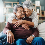 Cropped shot of a cheerful elderly woman hugging her husband who's in a wheelchair at home during the day