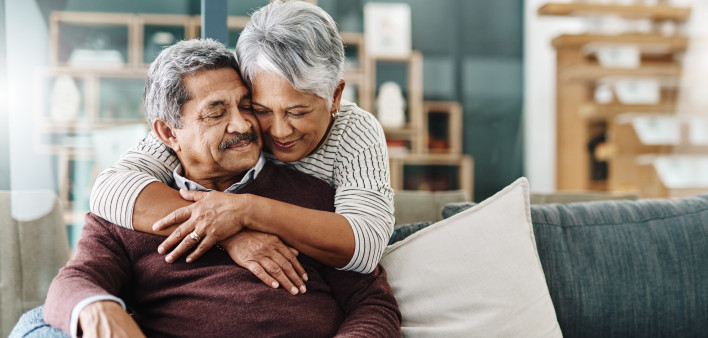 Cropped shot of a cheerful elderly woman hugging her husband who's in a wheelchair at home during the day