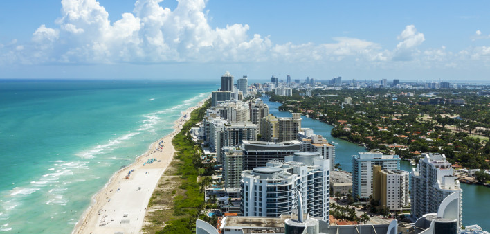 Looking down South Beach in Miami. Full view of the beach on the left and the city on the right.