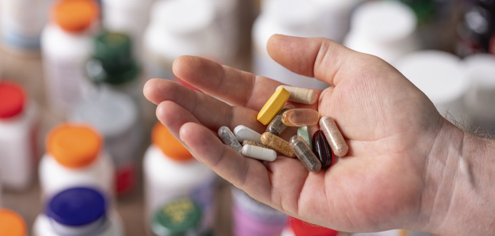 hand holding vitamins and supplements
