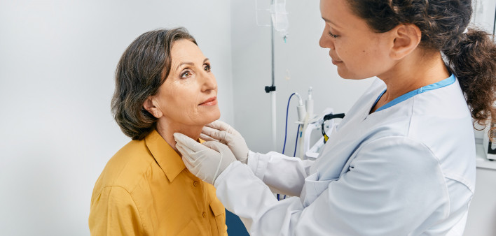 doctor checking a patients thyroid