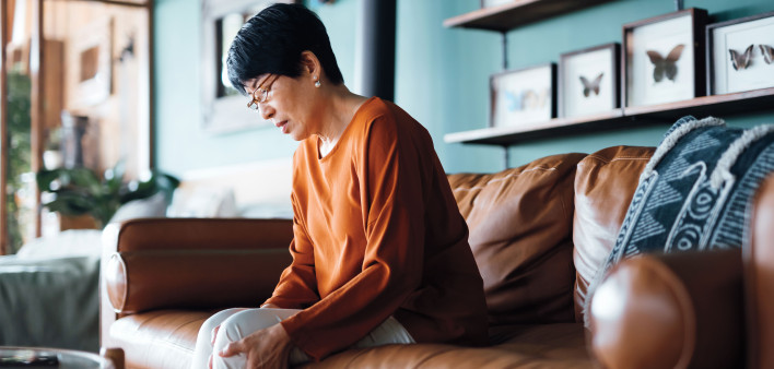 sad asian woman sitting on a couch