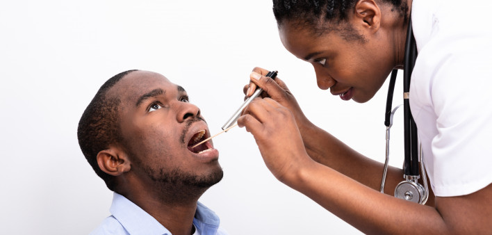 black man getting his throat checked by female nurse doctor