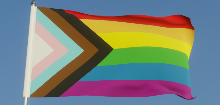 Inclusive LGBTQI+ Pride Flag Fluttering against a blue sky