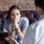 Young woman visiting therapist counselor.