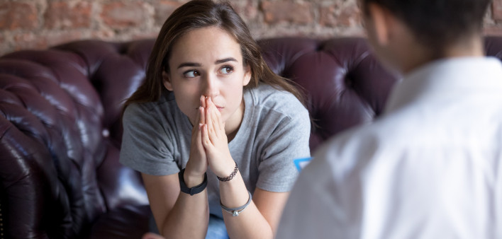 Young woman visiting therapist counselor.