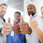 doctors, nurses and patient giving thumbs up
