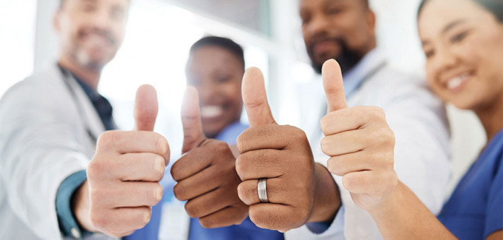 doctors, nurses and patient giving thumbs up