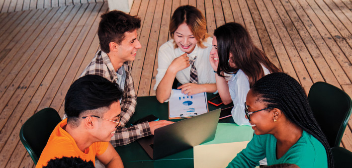 group of young people socializing around a table