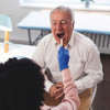 paitent having mouth examined with a tounge depresser