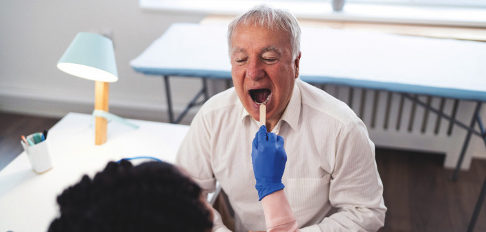 paitent having mouth examined with a tounge depresser