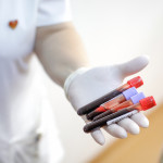 female medical worker holding blood vials after a blood donation