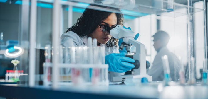 Medical Science Laboratory: Portrait of Beautiful Black Scientist Looking Under Microscope
