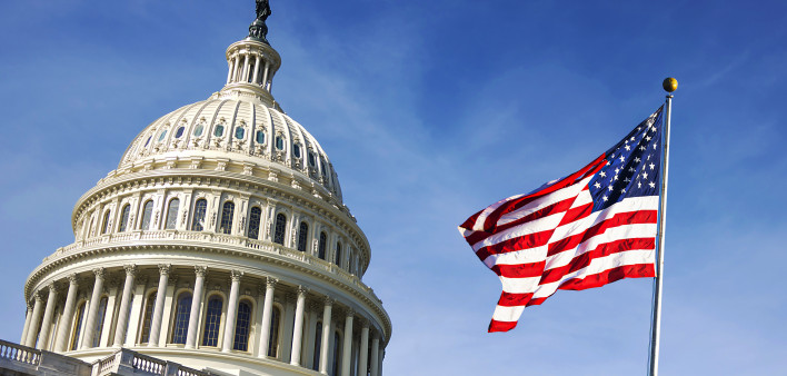 American flag waving with the Capitol Hill in the background