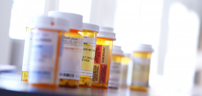 Several prescription medication bottles sit on a table.