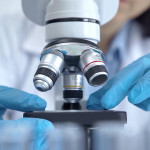 Scientist using microscope in laboratory.