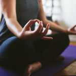 Cropped shot of an unrecognizable woman sitting on a yoga mat and meditating alone in her home