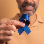 man holding blue ribbon for prostate cancer awareness