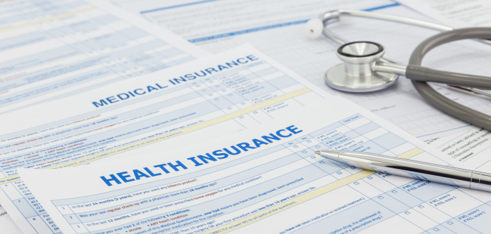Medical insurance application, silver pen and stethoscope. Legal law contract and health insurance concepts.