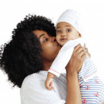 black woman holding and kissing baby