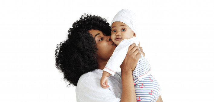 black woman holding and kissing baby