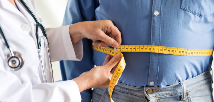 doctor measuring mans stomach