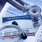 A Medicare insurance card and a stethoscope rest on top of a hospital medical invoice.
