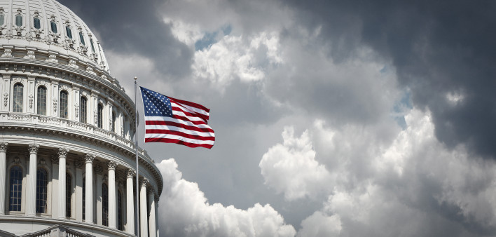 American flag waving with the Capitol Hill in the background