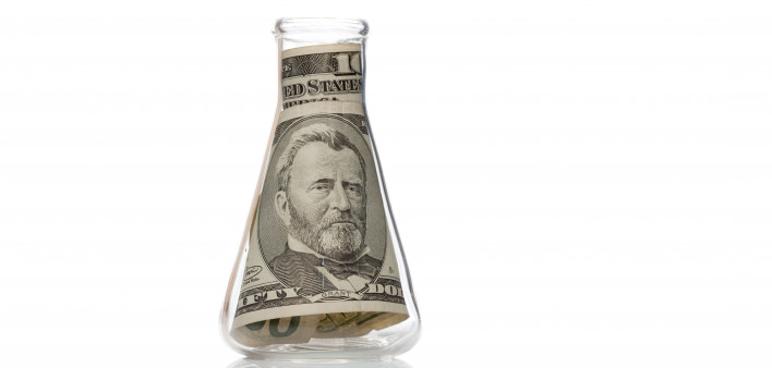 Us dollar in laboratory tube flask beaker