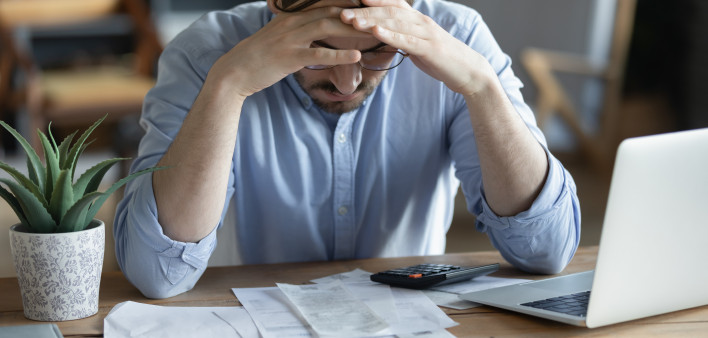Sad depressed man checking bills, anxiety about debt or bankruptcy