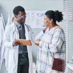Young African American doctor consulting female patient