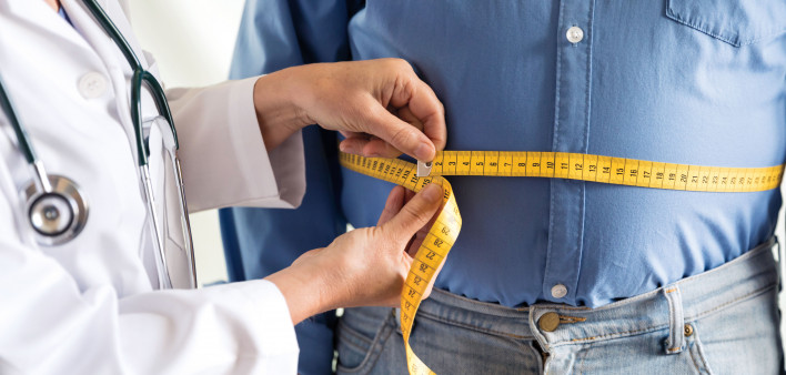 doctor measuring mans stomach
