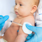 Doctor Giving Vaccination To Baby At Clinic