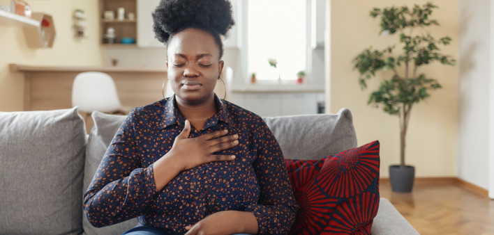 Pressure in the Chest. Close-up Photo of a Stressed Obese African American Woman Who Is Suffering From a Chest Pain and Touching Her Heart Area.