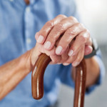 old man's hands on a cane