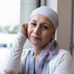 A peaceful photo of a breast cancer patient wearing a scarf to cover her head.