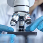 Scientist using microscope in laboratory.