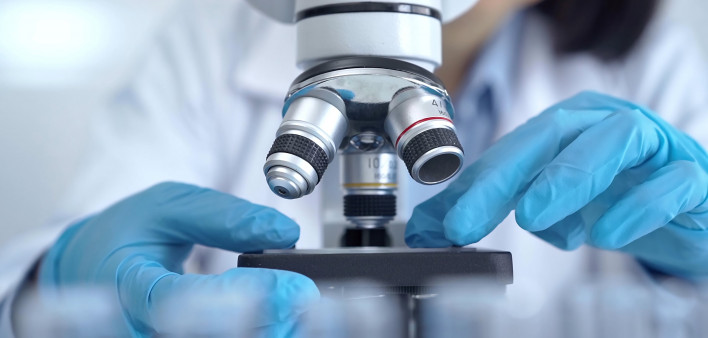 Scientist using microscope in laboratory.