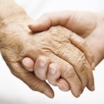 one hand holds the other elderly hand