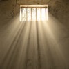 light shining through bars of prison window 