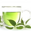 a cup of green tea and fresh tea leaves