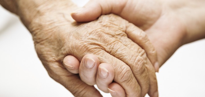 one hand holds the other elderly hand