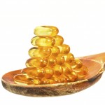 Vitamin D Capsules on wooden spoon